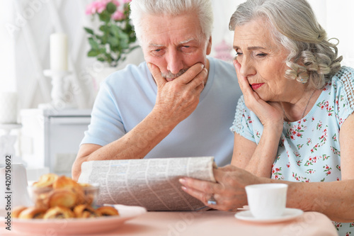 Close-up portrait of a senior couple with newspaper