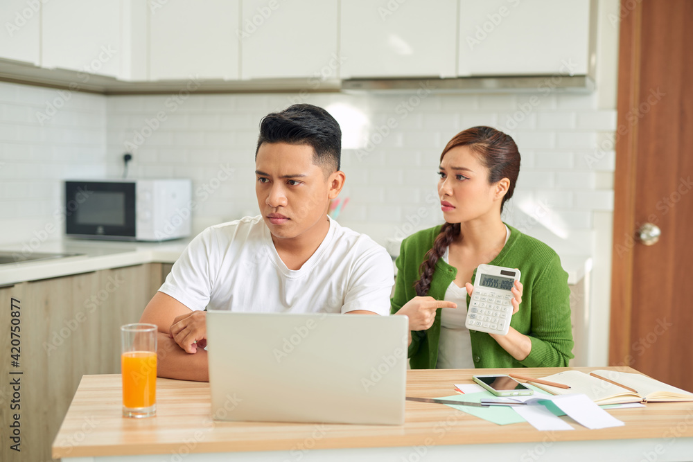 Upset young woman with financial bills having conflict with man at home Upset young woman with financial bills having conflict with man at home