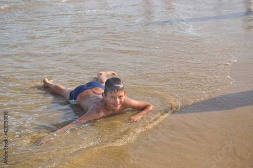 child swims in the sea waves on the beach