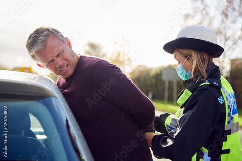 Fotografie Male Driver Being Handcuffed And Arrested By Female Traffic Police Officer For D