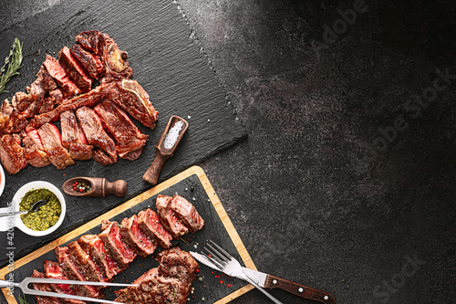 Obraz na płótnie two steaks striploin and t-bon, medium rare, on a stone background. dinner concept for two w salonie