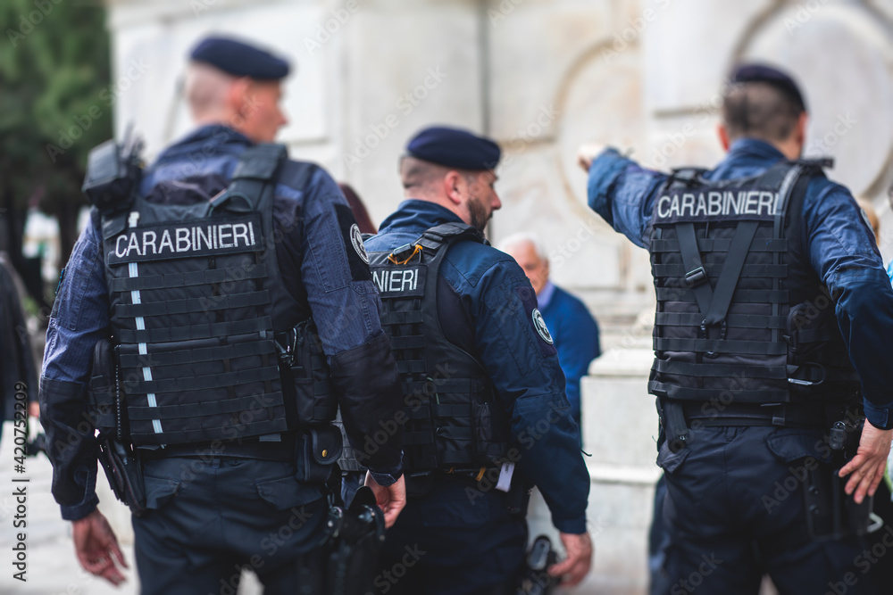 Italian Carabinieri, national gendarmerie of Italy squad, of Italy patrol  formation back view with "Carabiners" logo emblem on uniform maintain  public order in the streets of Florence, Tuscany, Italy Stock Photo