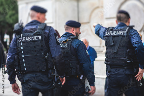 Italian Carabinieri, national gendarmerie of Italy squad, of Italy patrol formation back view with "Carabiners" logo emblem on uniform maintain public order in the streets of Florence, Tuscany, Italy