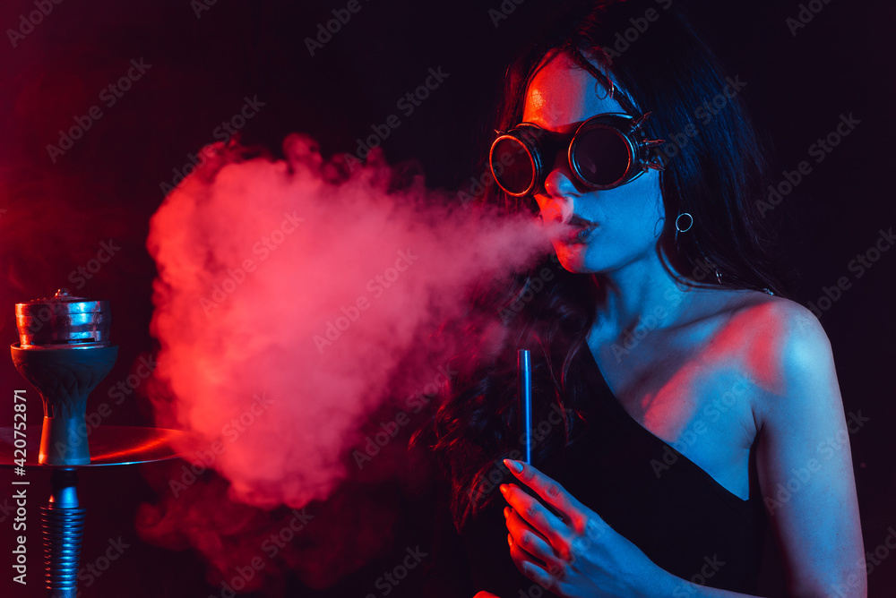 Hookah atmosphere. The girl enjoys smoking a hookah, sheesha