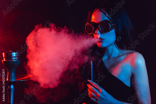 Fototapeta Naklejka Na Ścianę i Meble -  Hookah atmosphere. The girl enjoys smoking a hookah, sheesha. Surrealism