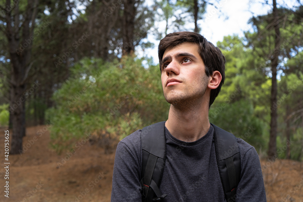 Young man in a forest observing nature Young man in a forest observing nature