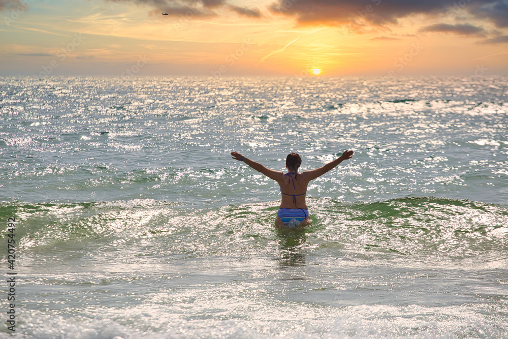 Fototapeta premium woman bathes in sea waves on the beach