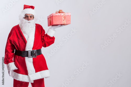 Babbo natale porge un pacco color rosso , isolato su sfondo bianco photo