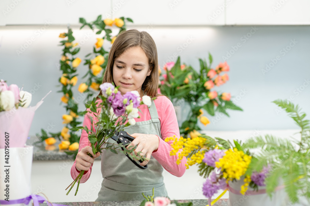 Young girl cutting flower with scissors at flower shop. Hobby and leisure concept Young girl cutting flower with scissors at flower shop. Hobby and leisure concept