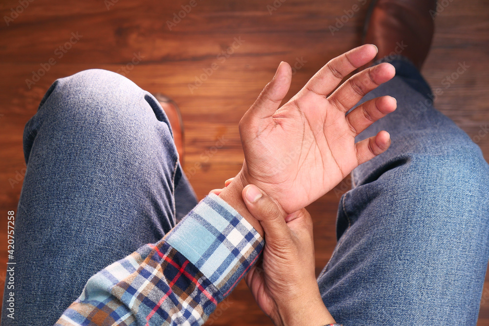 top view of man suffering pain in hand close sitting on chair top view of man suffering pain in hand close sitting on chair