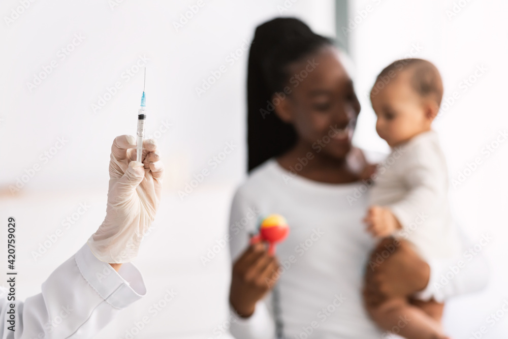 African American mother holding baby for vaccination African American mother holding baby for vaccination