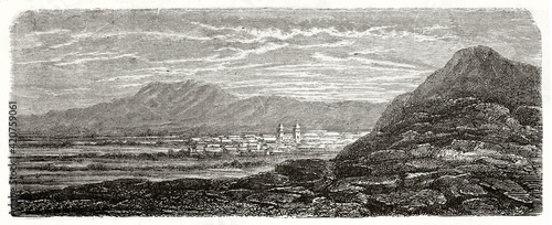 distant view of Lampa, Peru, on a large flatland from a rocky hill. Mountain range far in background. Ancient grey tone etching style art by Riou, Le Tour du Monde, 1862