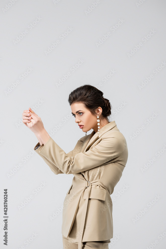 fashionable woman looking away while posing with clenched hands isolated on grey fashionable woman looking away while posing with clenched hands isolated on grey