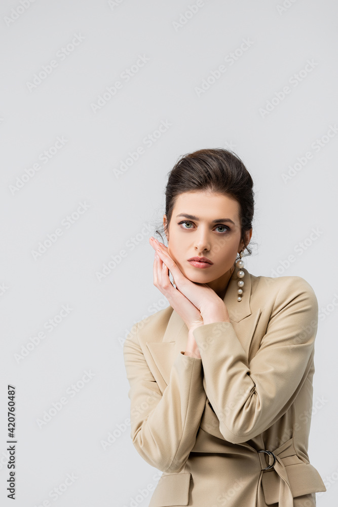 sensual, trendy woman in pearl earrings posing with hands near face isolated on grey sensual, trendy woman in pearl earrings posing with hands near face isolated on grey