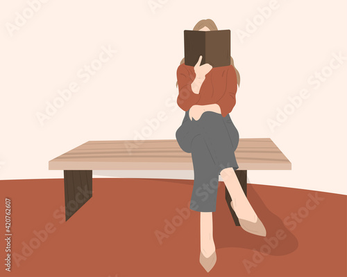 Beautiful young woman wearing casual outfit and fashionable shoes sitting on the bench reading a book covering her face