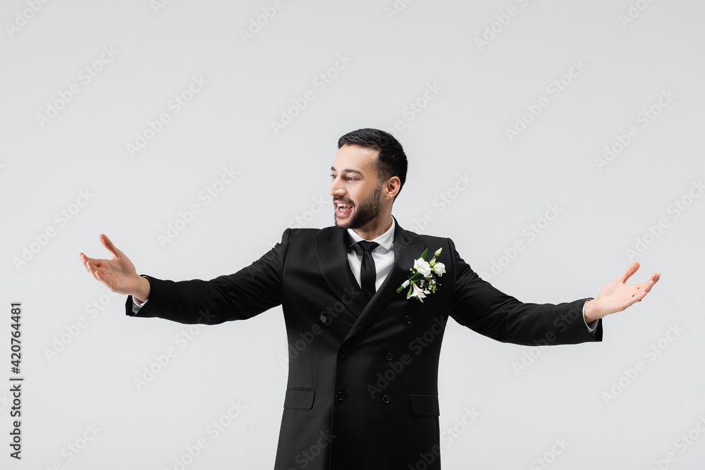 Cheerful arabian groom in elegant suit isolated on grey Cheerful arabian groom in elegant suit isolated on grey