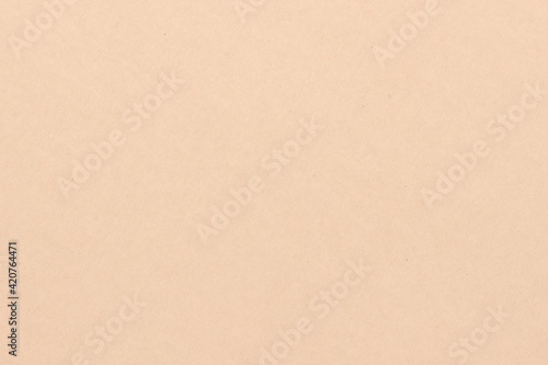 The surface of a light beige cardboard sheet. Light uniform brown texture.