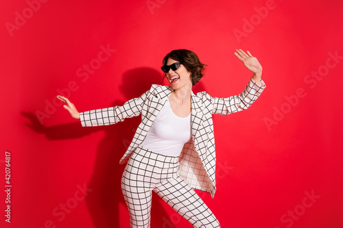 Photo of young attractive girl crazy happy smile have fun enjoy music dance party isolated over red color background