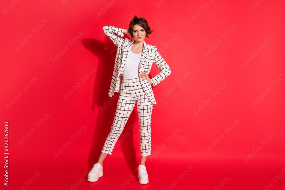 Full size photo of young beautiful happy positive smiling businesswoman hold hand behind head isolated on red color background Full size photo of young beautiful happy positive smiling businesswoman hold hand behind head isolated on red color background