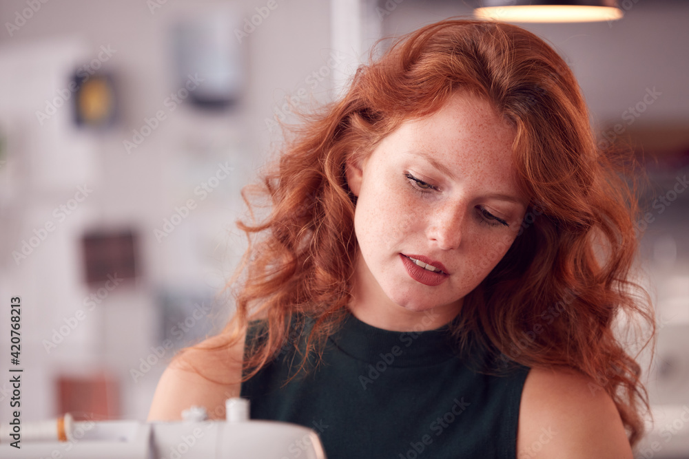 Fototapeta premium Close Up Of Female Student Or Business Owner Working In Fashion Using Sewing Machine In Studio