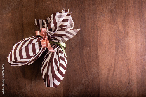 Photography Top view of two wrapped easter eggs on a wooden table.