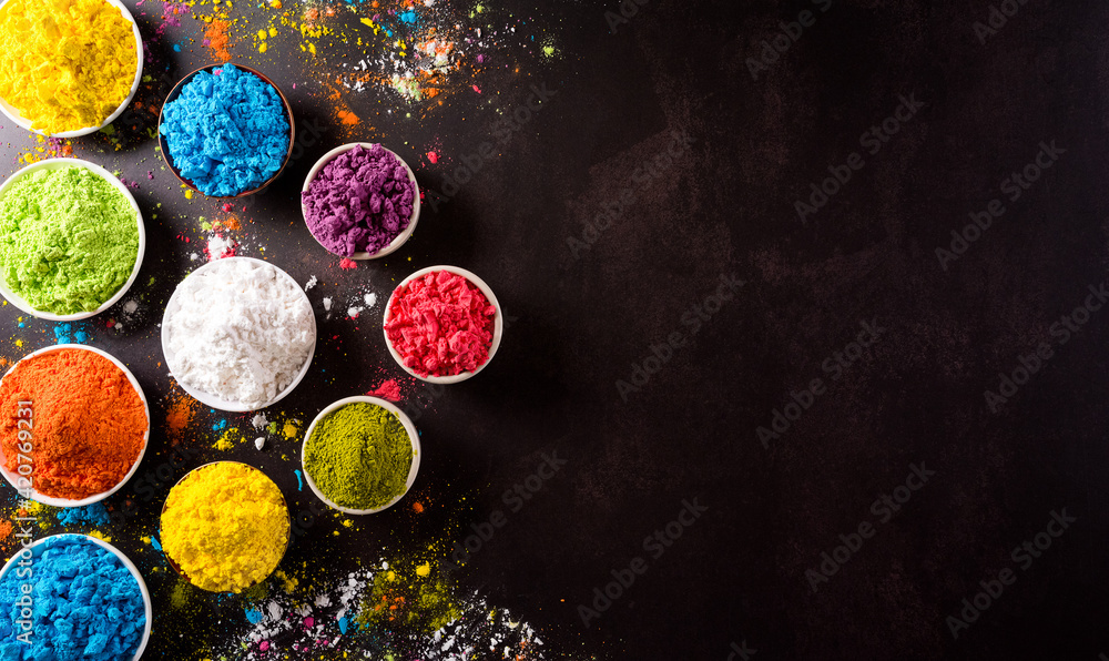 Happy holi festival  view of colorful holi powder on dark  background with copy space for text. Stock Photo | Adobe Stock