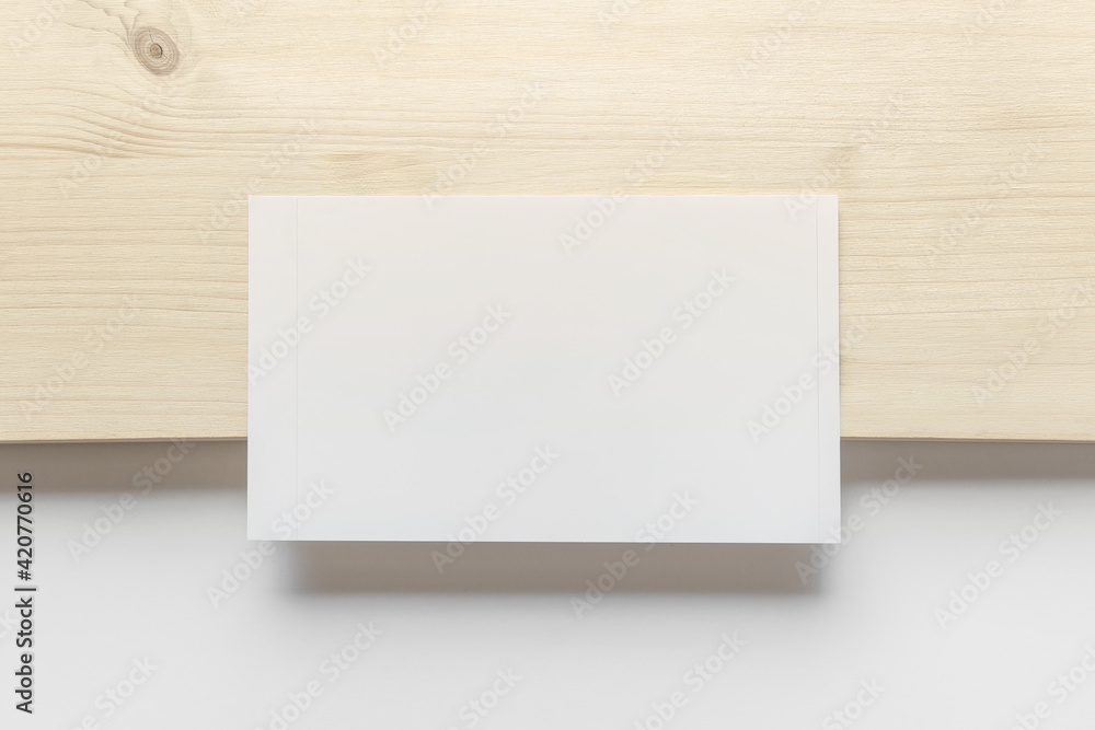 Mockup template with blank photo card on wooden and white paper background. Mockup template with blank photo card on wooden and white paper background.