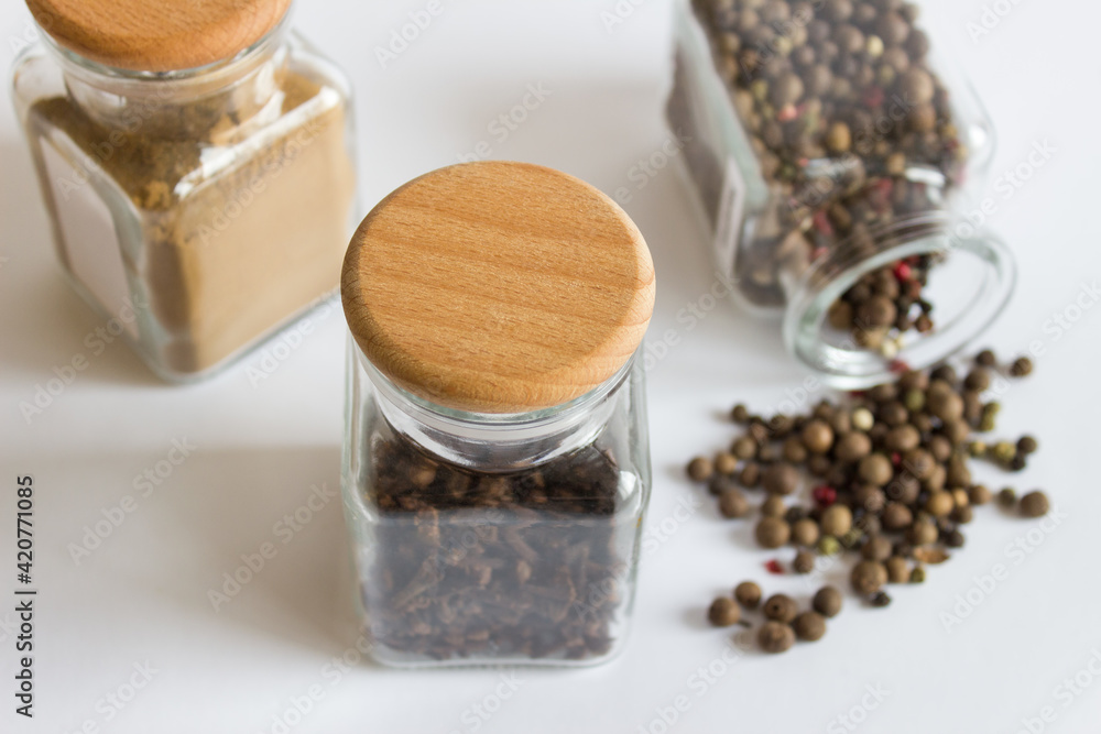 Closeup mockup template with three jars glass hermetic bottles with wooden caps and spices seasonings on white background. Closeup mockup template with three jars glass hermetic bottles with wooden caps and spices seasonings on white background.