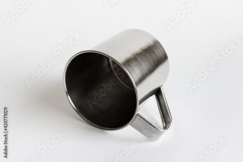 Mockup template of single silver shiny metallic stailess steel mug laying on white background. photo