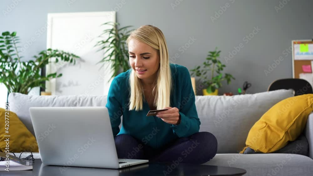 oung woman paying with credit card for online shopping at home using laptop oung woman paying with credit card for online shopping at home using laptop