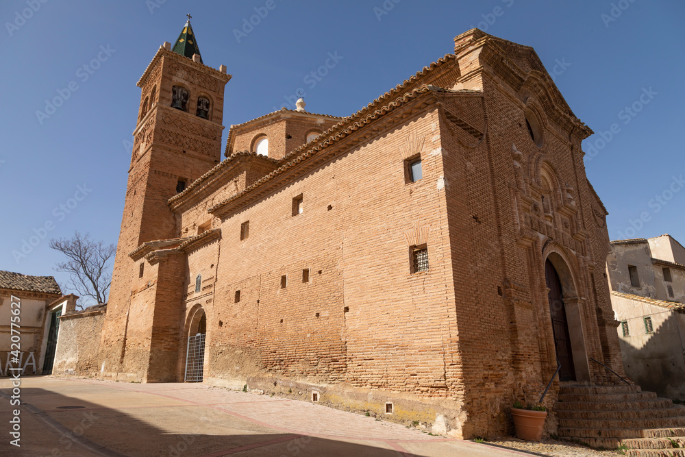 Photograph of the bell tower and the church of Our Lady of the Rosary, of baroque mudejar architecture style, in the small town of Ambel, in the Campo de Borja region, Zaragoza, Aragon, Spain.