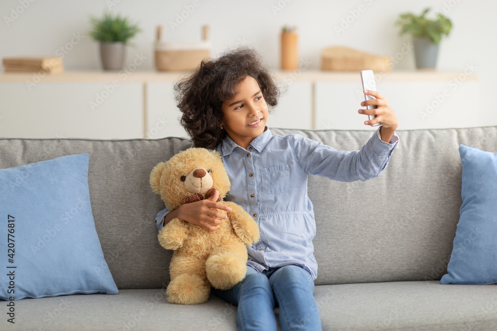 Cheerful black teenage girl taking selfie for social network Cheerful black teenage girl taking selfie for social network