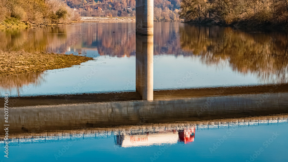 Beautiful autumn or indian summer view with a mirror image of a truck on the surface of the danube river near Mettenufer, Danube, Bavaria, Germany