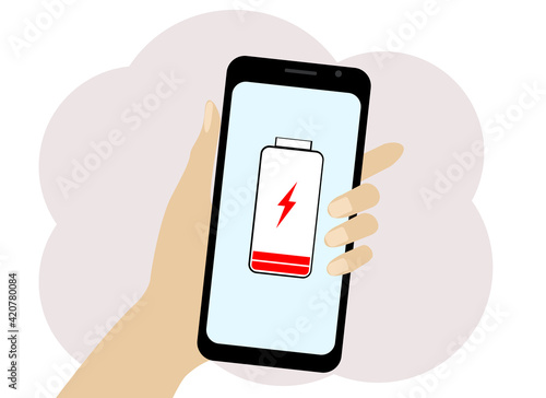 Hand with a mobile phone. The phone has a low battery symbol.