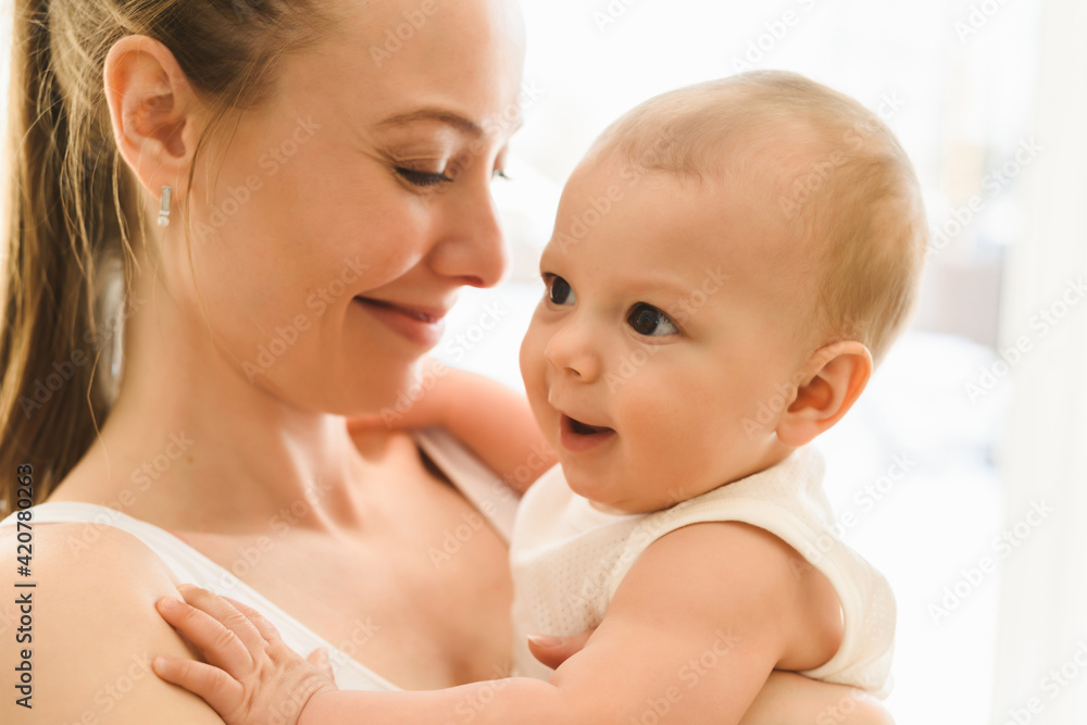 Mother and baby close-up. Mom holds the child in her arms, hugs him and kisses him. Happy family concert Mother and baby close-up. Mom holds the child in her arms, hugs him and kisses him. Happy family concert