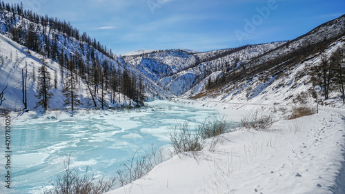 Valley among Sayan Mountains with Frozen Water Surface in Winter. Irkut River Covered with Ice and Snow, Russia