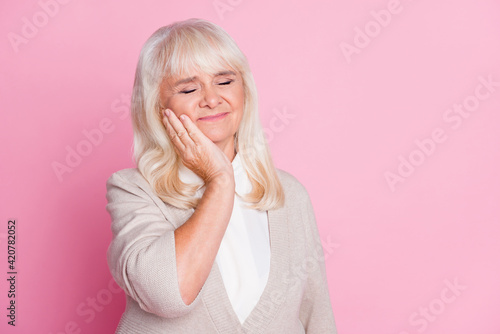 Photo portrait of woman having toothache touching cheek with hand isolated on pastel pink colored background