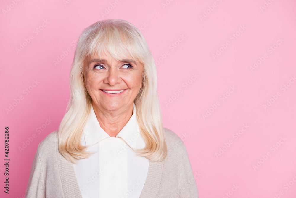 Photo portrait of smiling granny looking at blank space isolated on pastel pink colored background