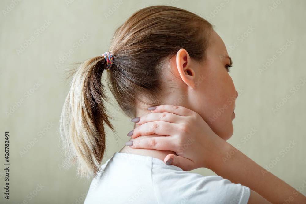 Naklejka premium Neck shoulder pain, cervical vertebrae. Woman holds neck with pain cervical muscle spasm by hand. Disease of musculoskeletal system in young woman. Health care and medical concept.