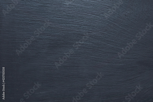 Full frame shot of grey textured surface lit by daylight. Slate stone texture background.