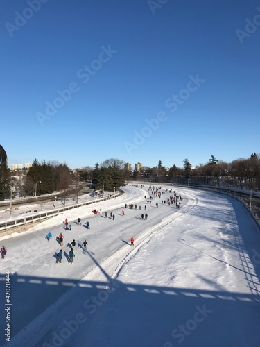 People ice skating on frozen Rideau canal. Recreation and leisure time activities during snowy winter. Ottawa, Ontario, Canada 