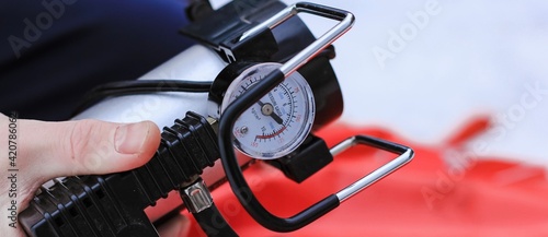 Man pumping air into tire of tube with mechanical pump on winter day. Equipment, device. Banner.	 photo