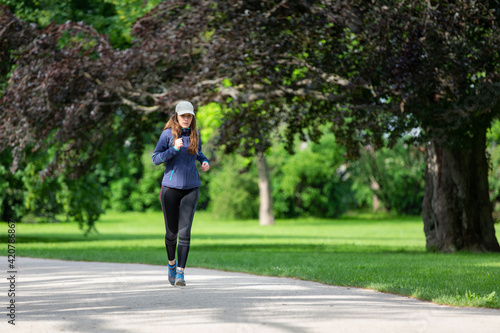 Young woman jogging in park on sunny day