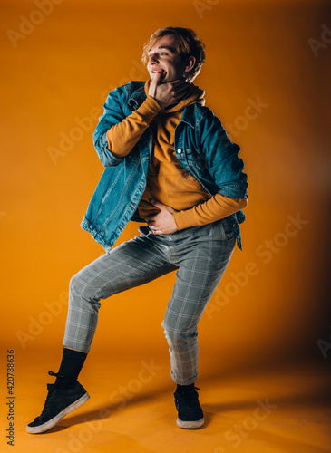 Athletic contemporary dancer isolated on orange wall