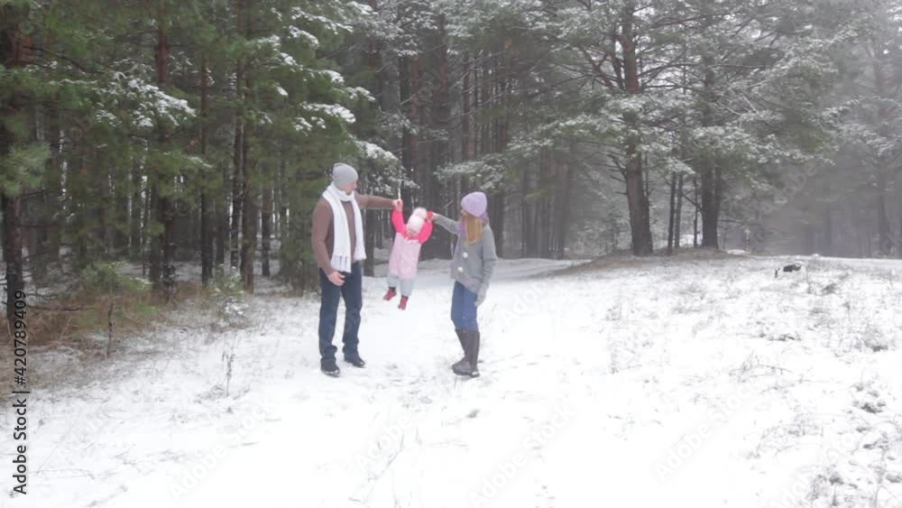 happy dad and mom play with their little baby in the winter forest happy dad and mom play with their little baby in the winter forest