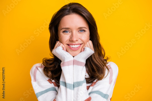 Close-up portrait of attractive cheerful girl wearing soft clothes isolated over bright yellow color background