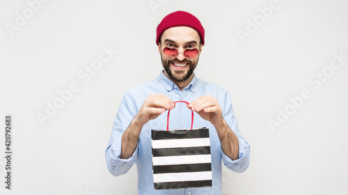 Wallpaper Mural Bearded man received a gift package, guy with glasses in the shape of a heart shows purchases, portrait, white background, copy space, 16:9 Torontodigital.ca