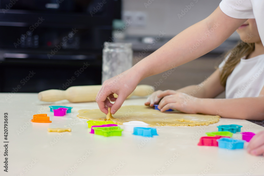 Two sisters are making homemade cookies in the kitchen. Two sisters are making homemade cookies in the kitchen.