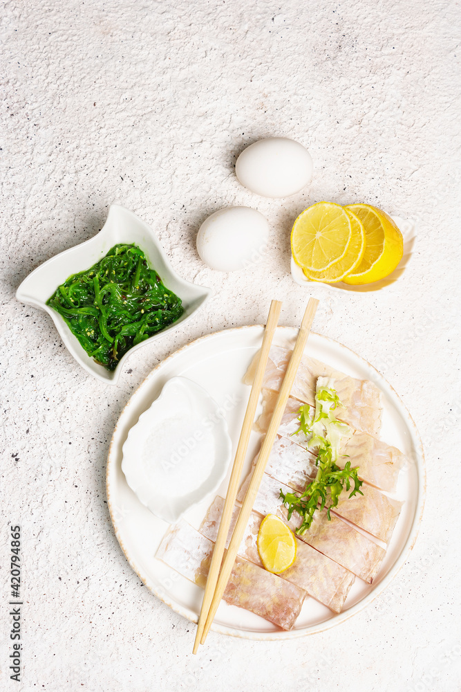 Pieces of raw hake, chukka salad, lemon wedge, fresh herbs, eggs as food preparation concept Pieces of raw hake, chukka salad, lemon wedge, fresh herbs, eggs as food preparation concept