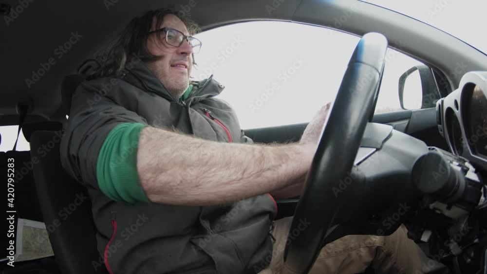 Frustrated an aggressive man in traffic having a road rage incident. He is honking and screaming at other drivers. Frustrated an aggressive man in traffic having a road rage incident. He is honking and screaming at other drivers.